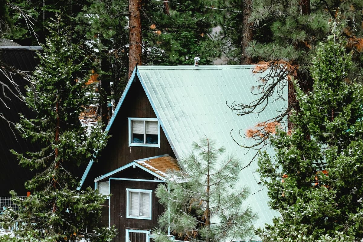 A mountain cabin among pine trees near Lake Tahoe after a light snow