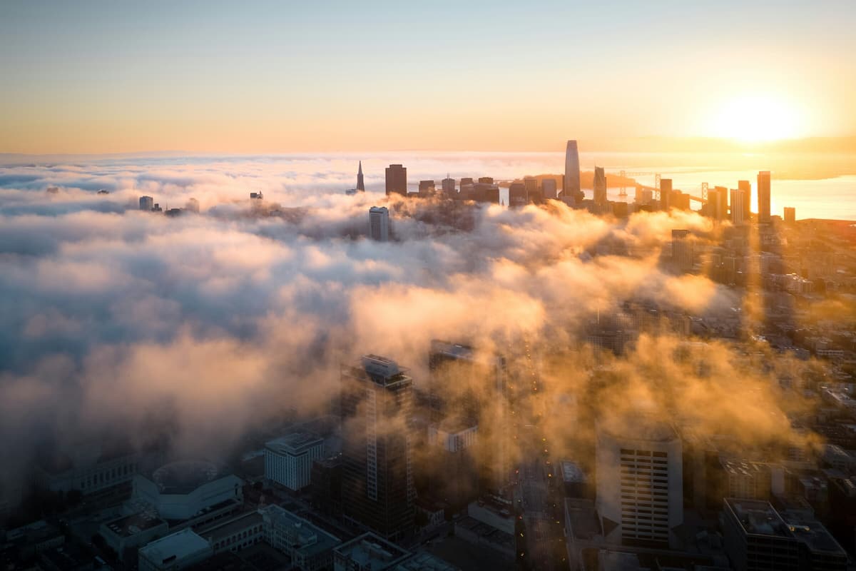 The San Francisco skyline rising out of a layer of morning fog at sunrise