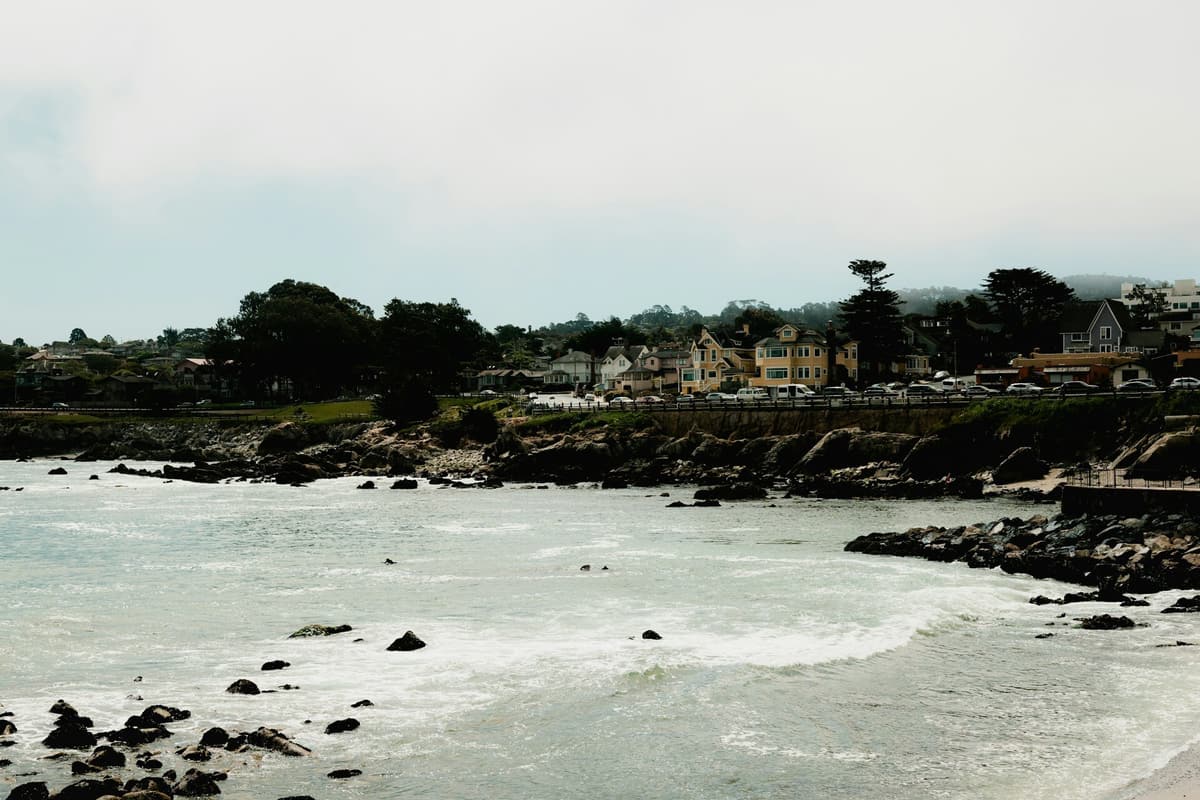 Waves breaking on a rocky shoreline below coastal homes on the Monterey Bay