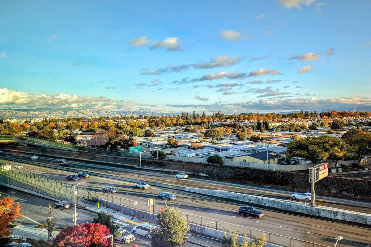 A freeway and neighborhoods in the San Jose area under an evening sky